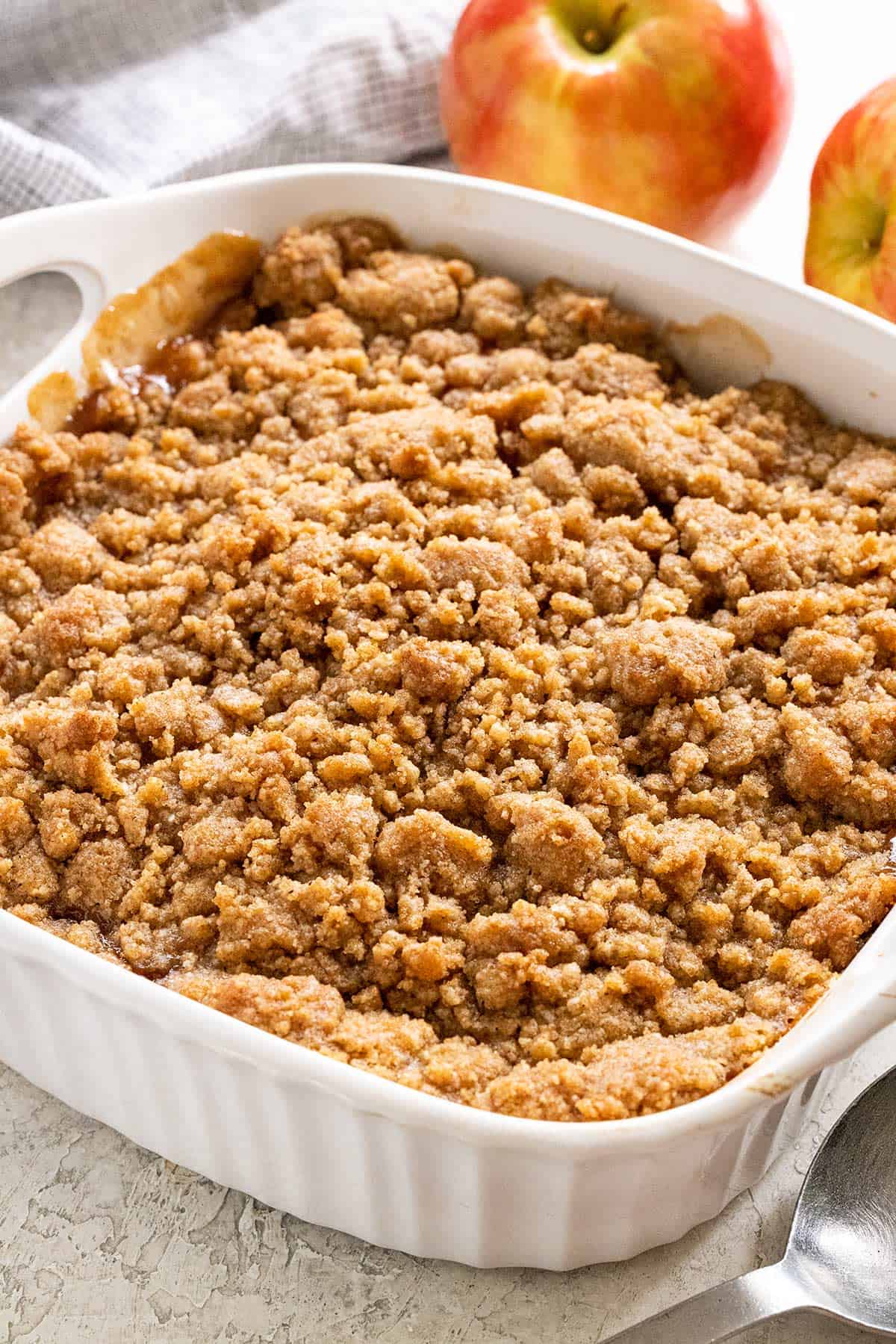 Freshly baked apple crumble in a white baking dish.