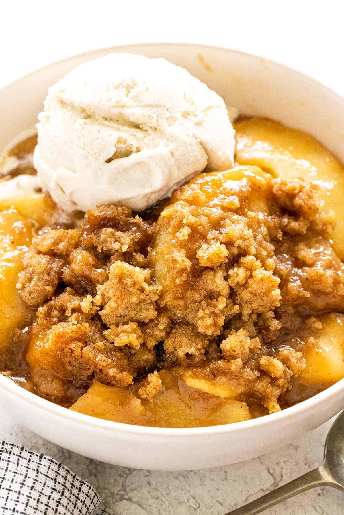 Bowl of apple crumble with a scoop of ice cream.