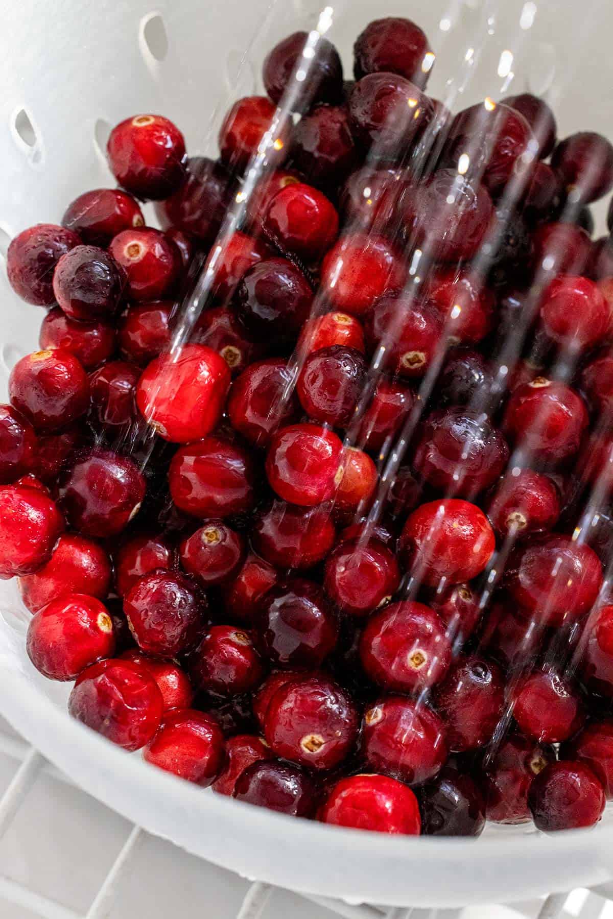 Rinsing cranberries in a colander.