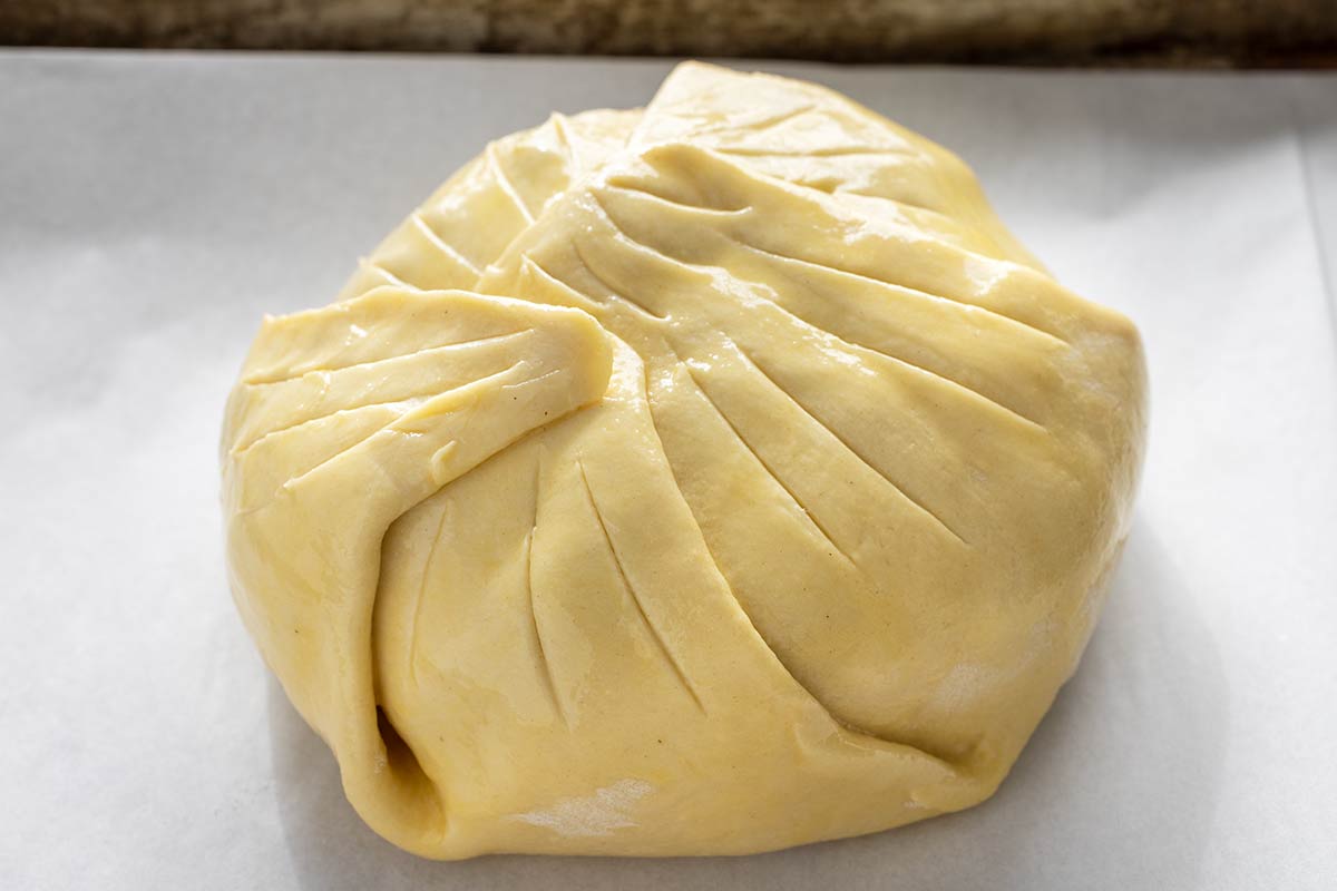 Brie wrapped in puff pastry with sliced vents.