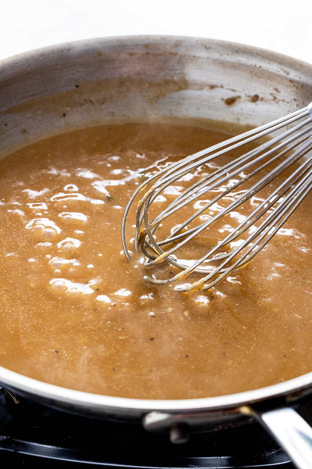 Whisking gravy in a pan.