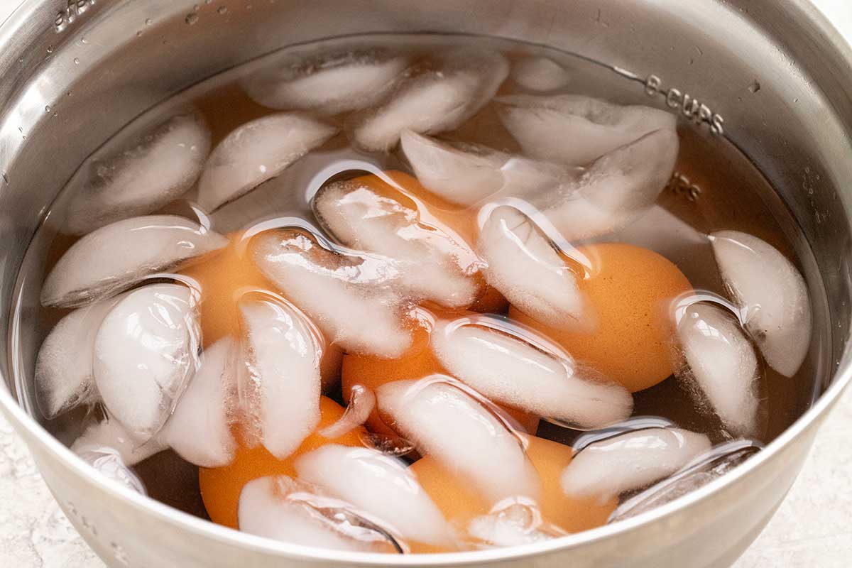 Hard boiled eggs placed in a bowl of ice water.