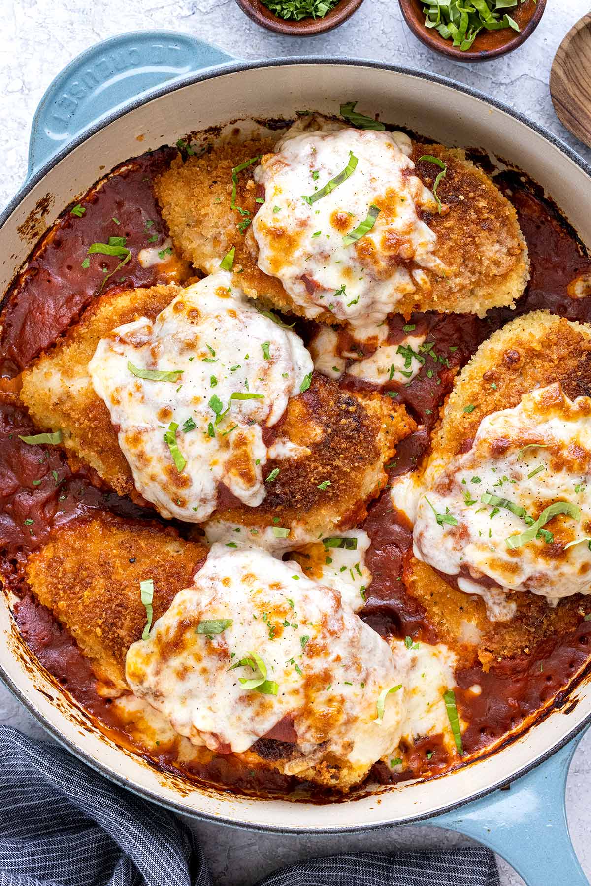 Serving stuffed chicken parmesan in a large skillet.
