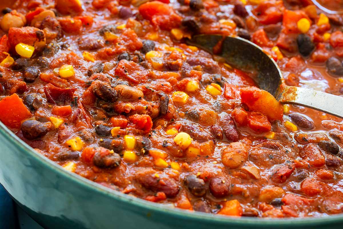 Close up of a pot of vegetarian chili simmering on the stove top.