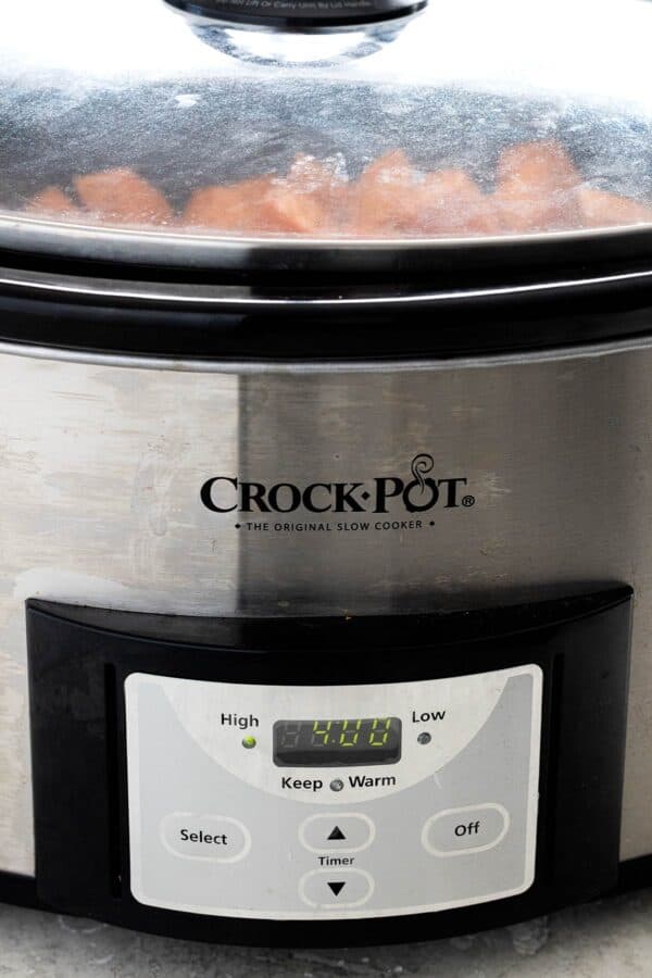 Chunks of sweet potatoes cooking in a crock pot.