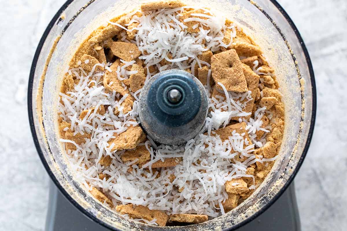Graham cracker and coconut inside a food processor.
