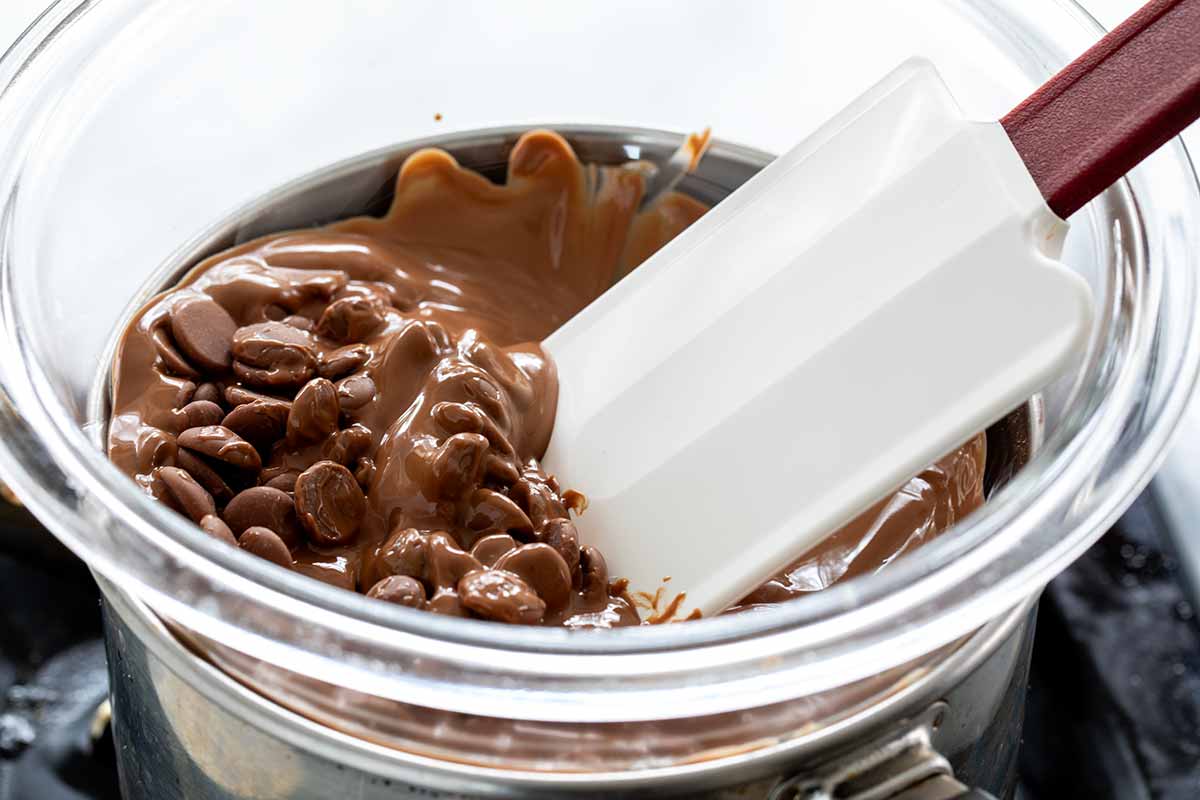 Spatula mixing a bowl of melting chocolate.