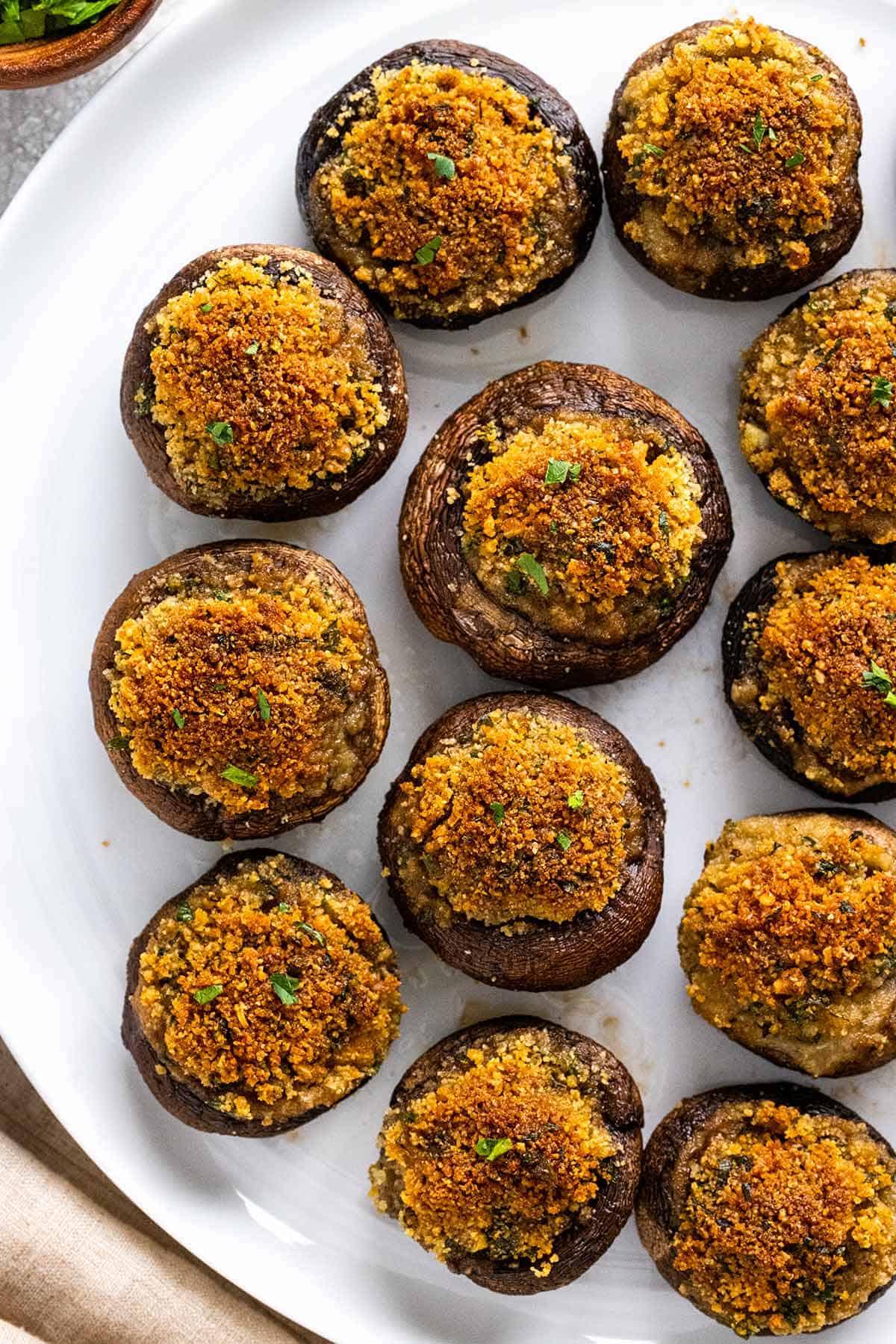 Stuffed mushrooms served on a white platter.