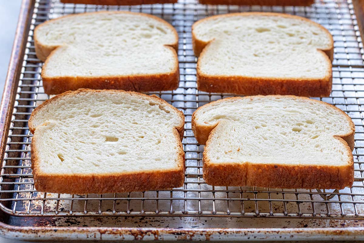 Slices of thick white bread on a wire rack.