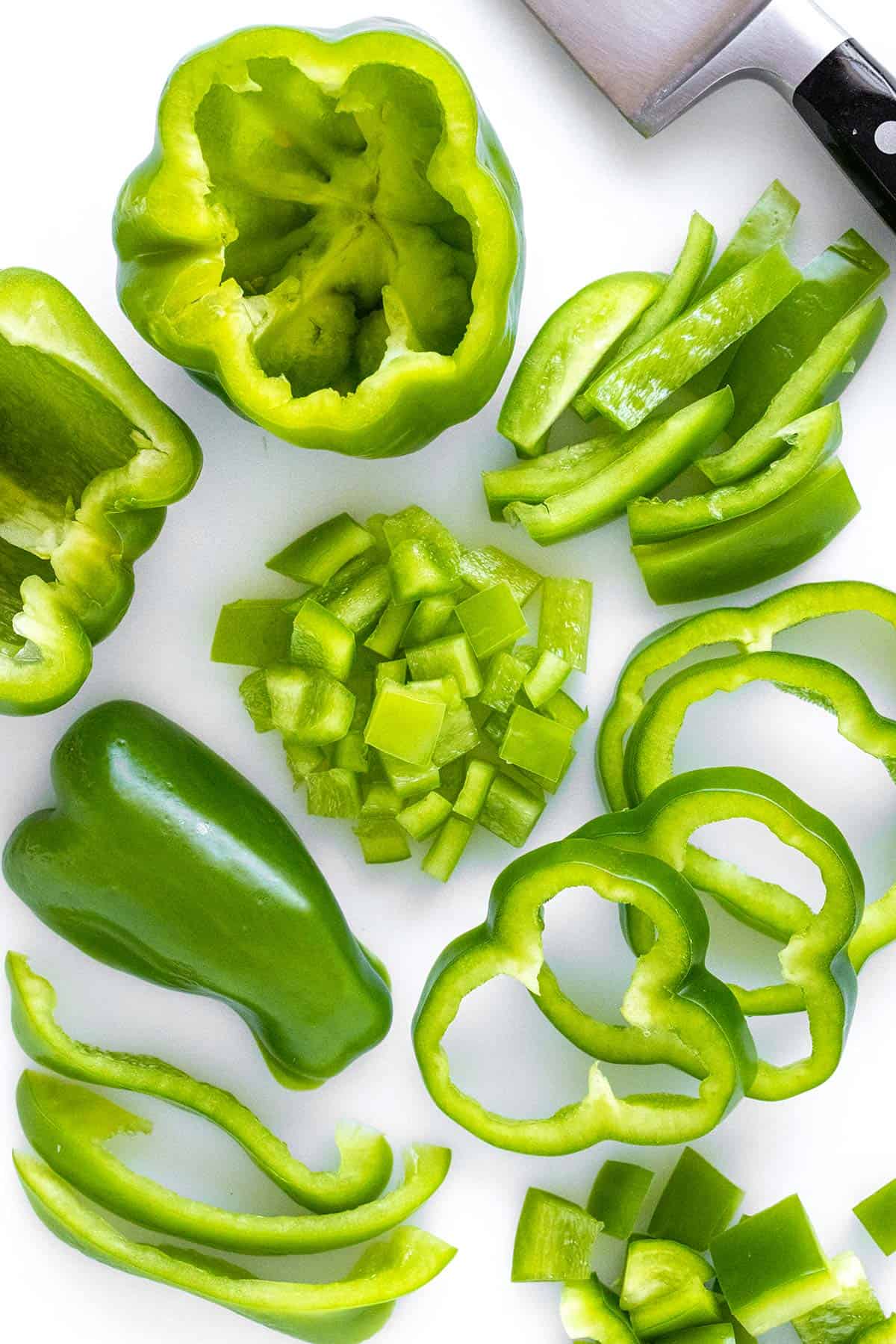 Green bell pepper cut and sliced into various shapes and sizes.