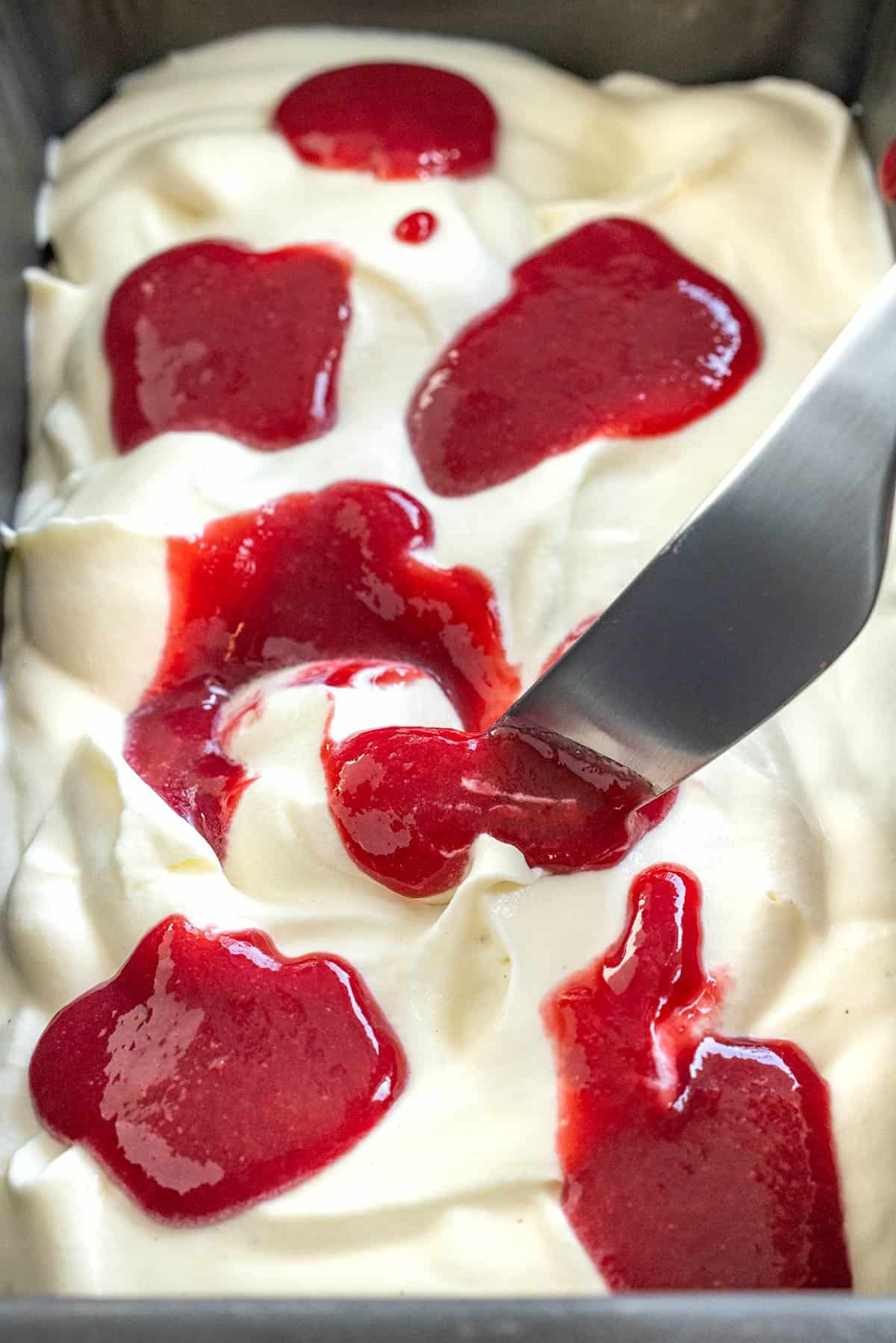 Raspberry sauce dotted over the ice cream base.