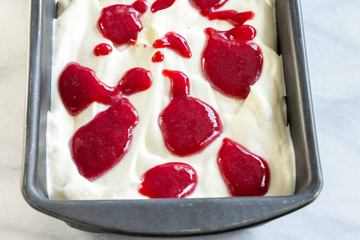 Raspberry sauce dotted over the ice cream base.