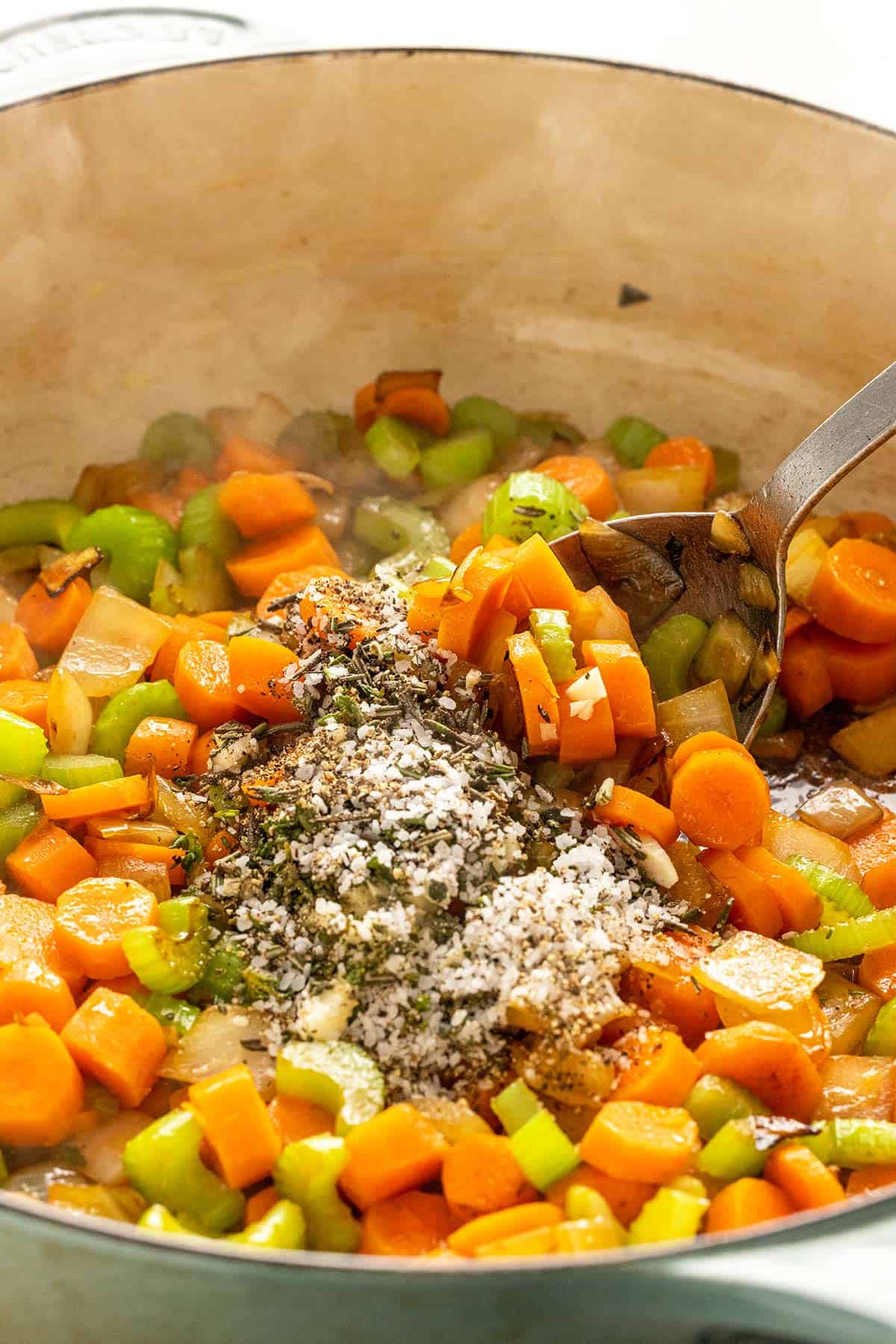 Carrots, celery, onions, and spices in a hot pan.