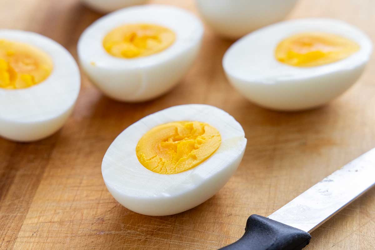 Hard boiled eggs cut in half on a wooden board.