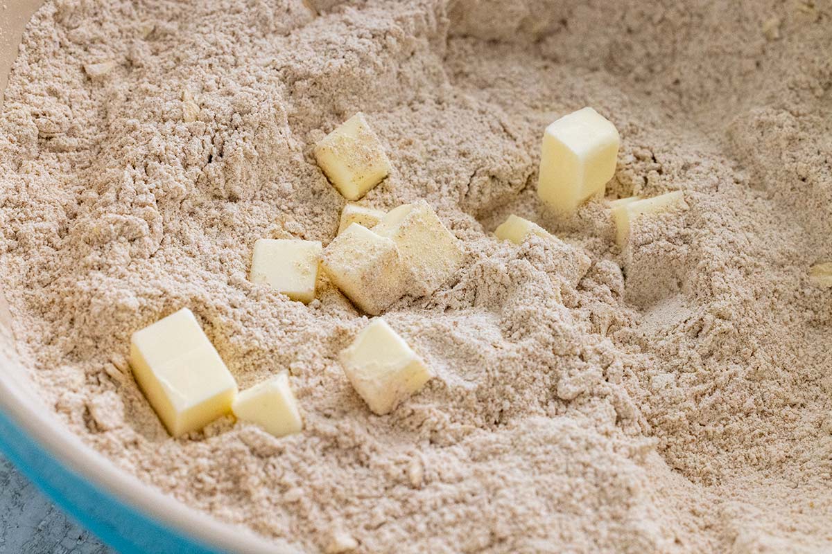 Cubes of cold butter added to a bowl of flour mixture.