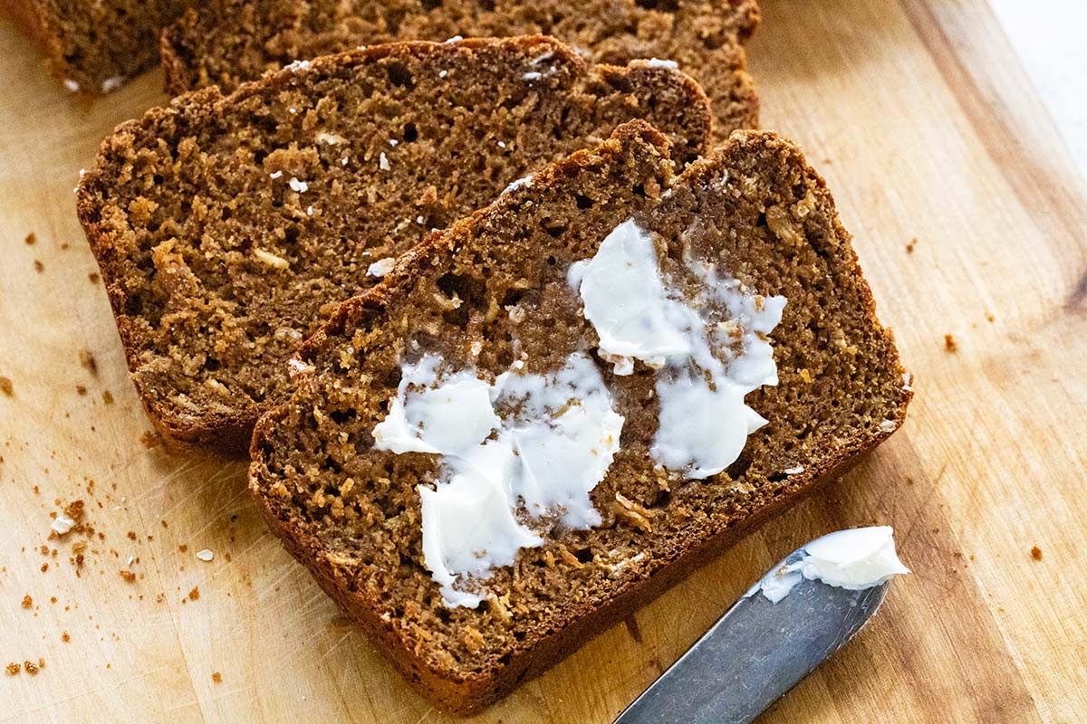 Irish brown bread with butter spread on one of the slices.