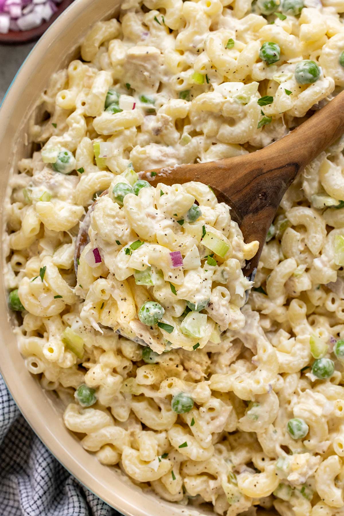 Bowl of tuna macaroni salad with wooden serving spoon.