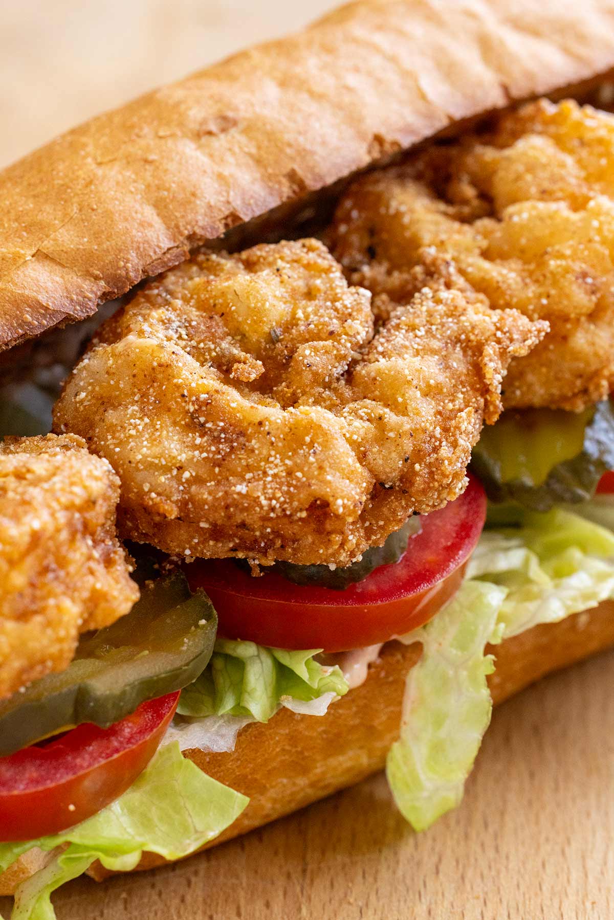 Pieces of deep fried shrimp inside a sandwich.
