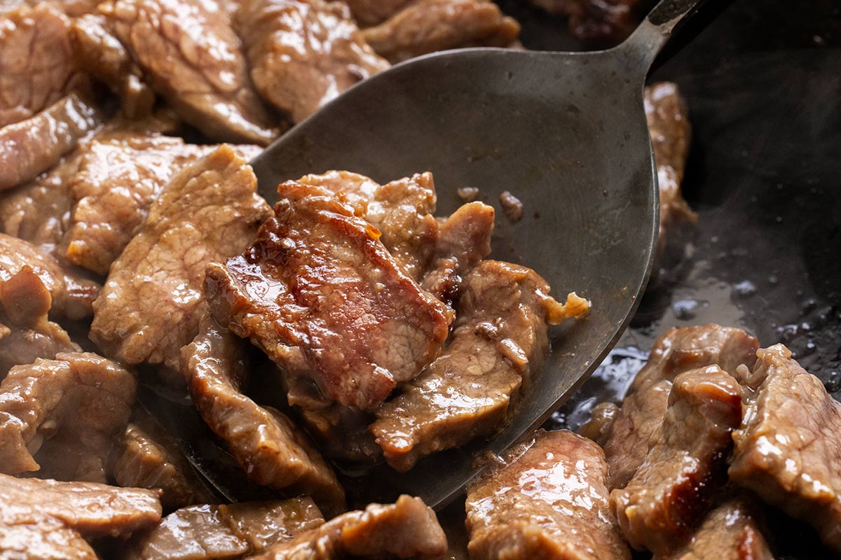 Steak being seared in a wok.