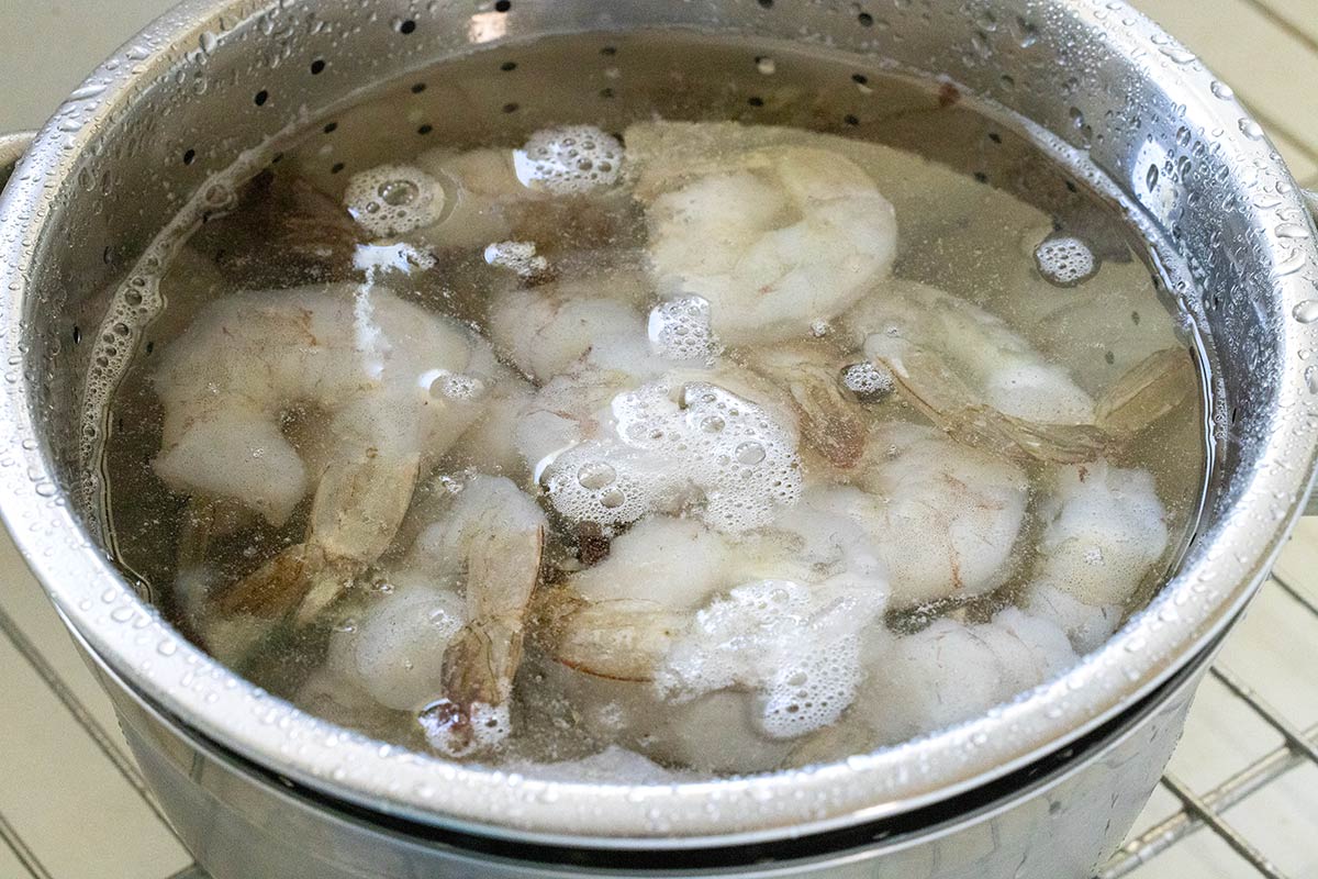 Frozen shrimp submerged in a bowl of water.