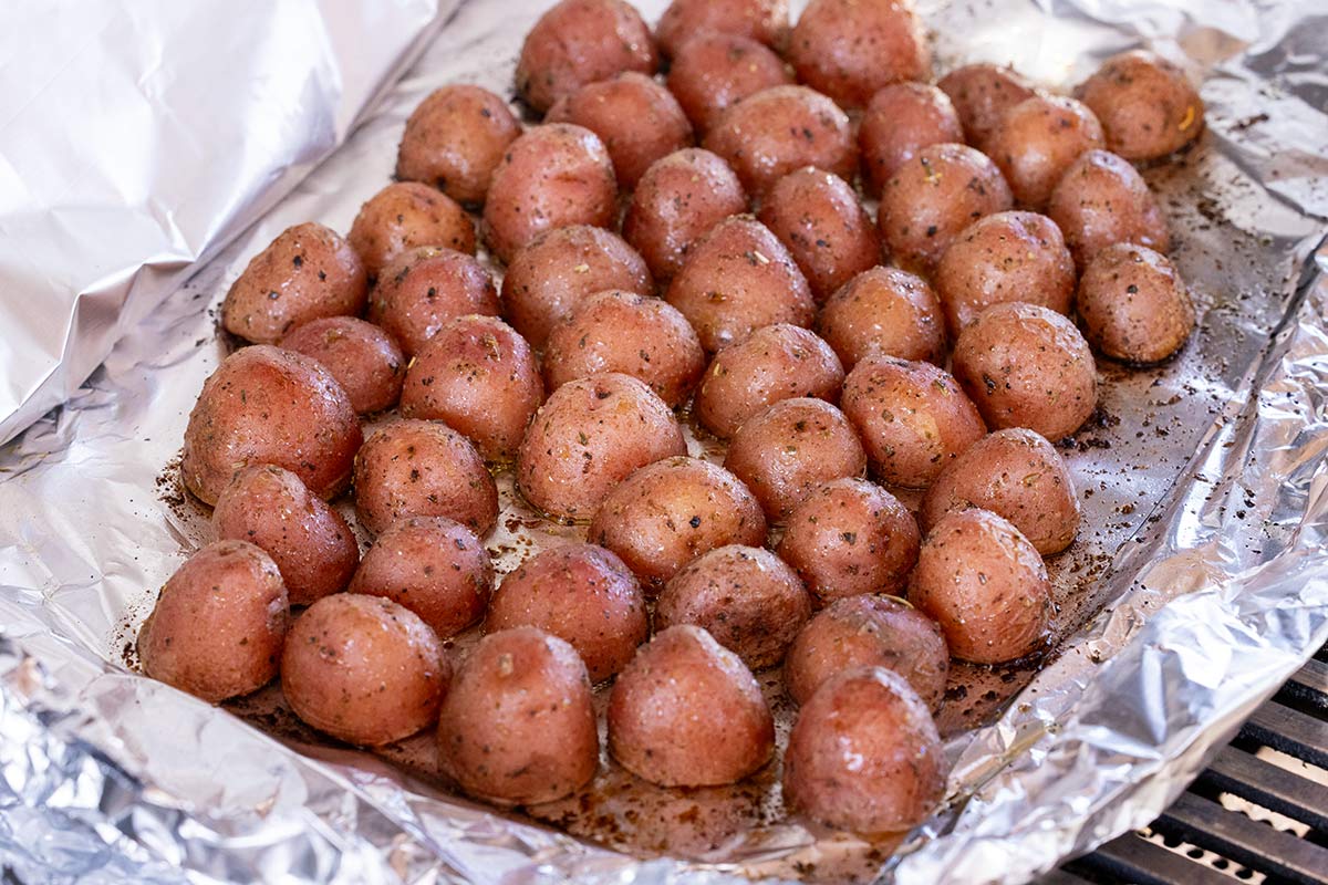 Foil packet of potatoes cooking on a bqq.