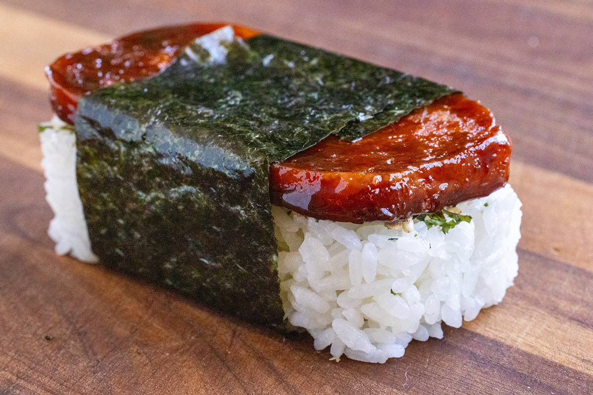 Homemade spam musubi on a wooden surface.