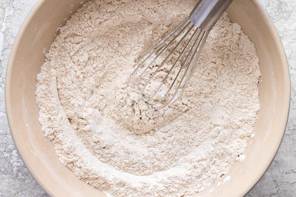 Bowl of dry flour and a metal whisk.
