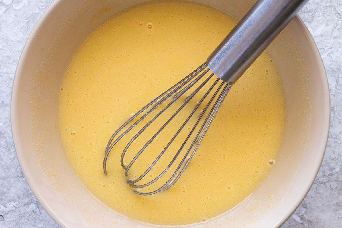 Bowl of whisked eggs and vanilla mixture.