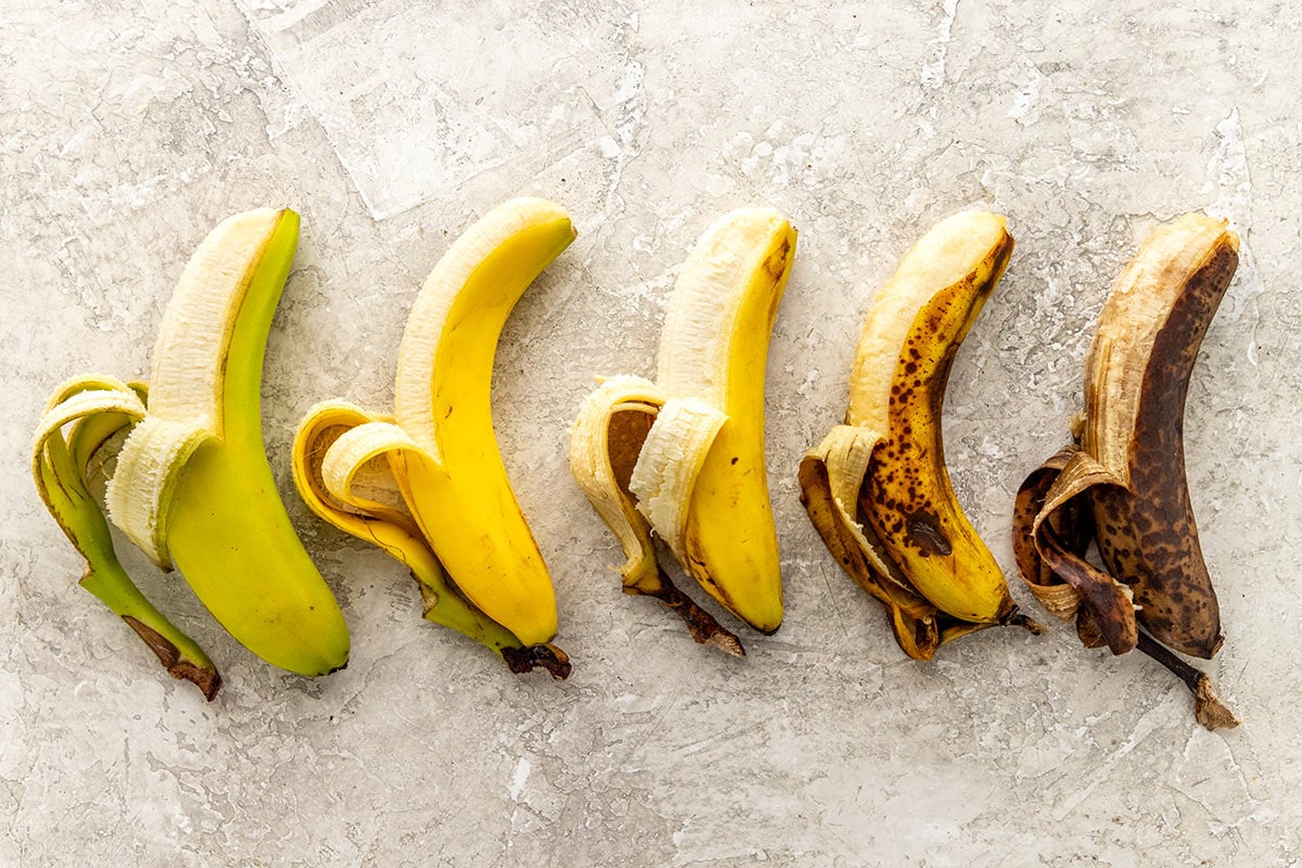 Five bananas with different levels of ripening.