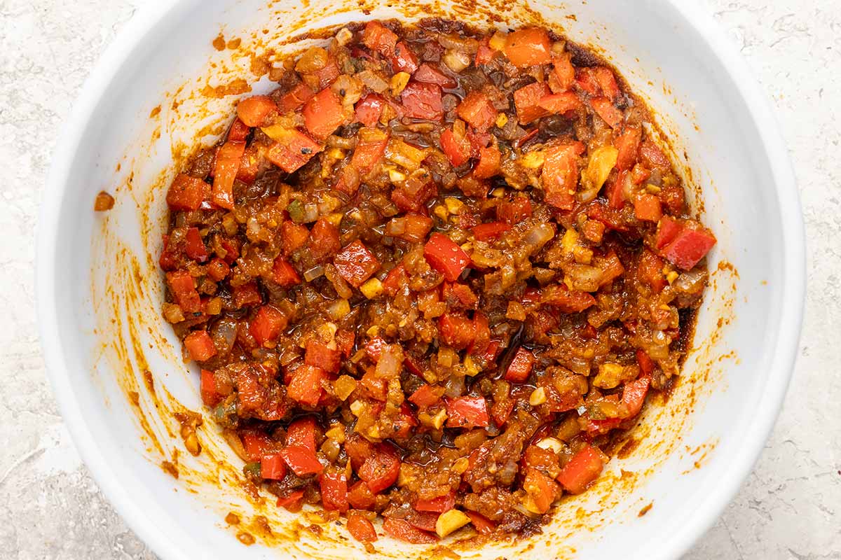 White bowl of spices and aromatics that have been mixed together.