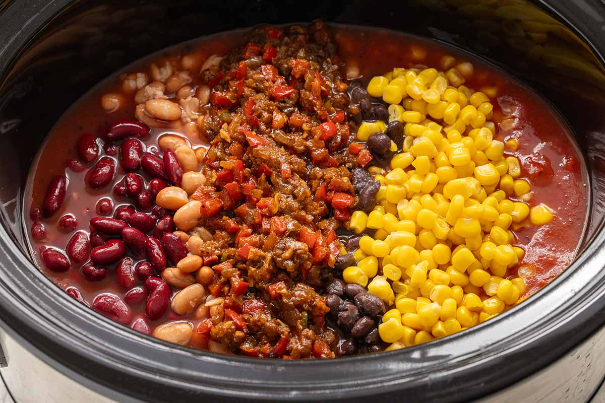 Bunch of chili ingredients tossed into a slow cooker.