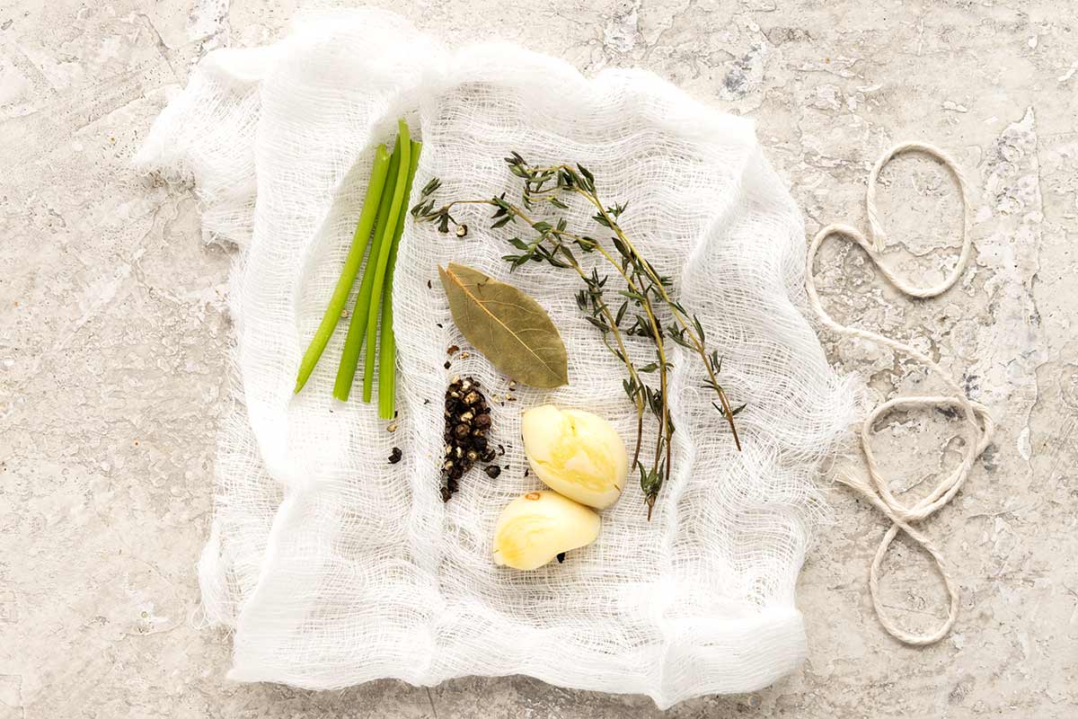 A sachet d&rsquo;epices spread out showing the ingredients inside the cloth.