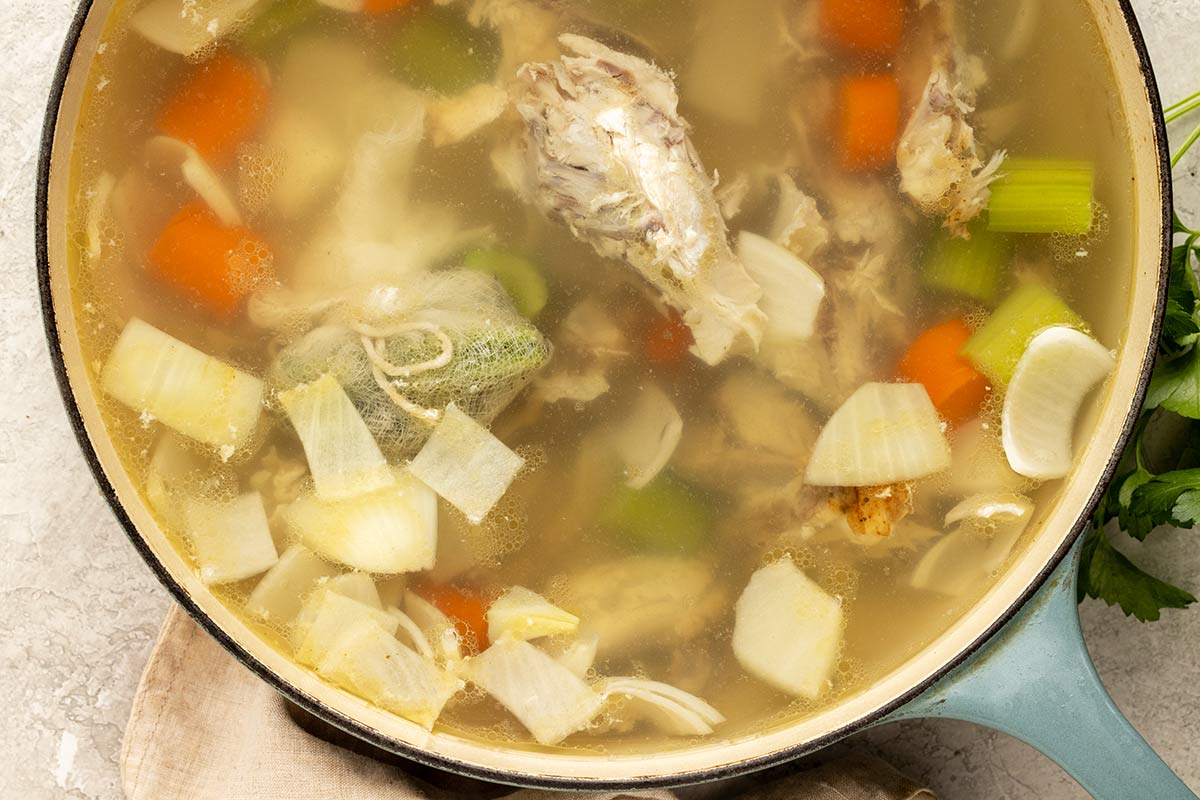 Chicken stock simmering in a large pot.