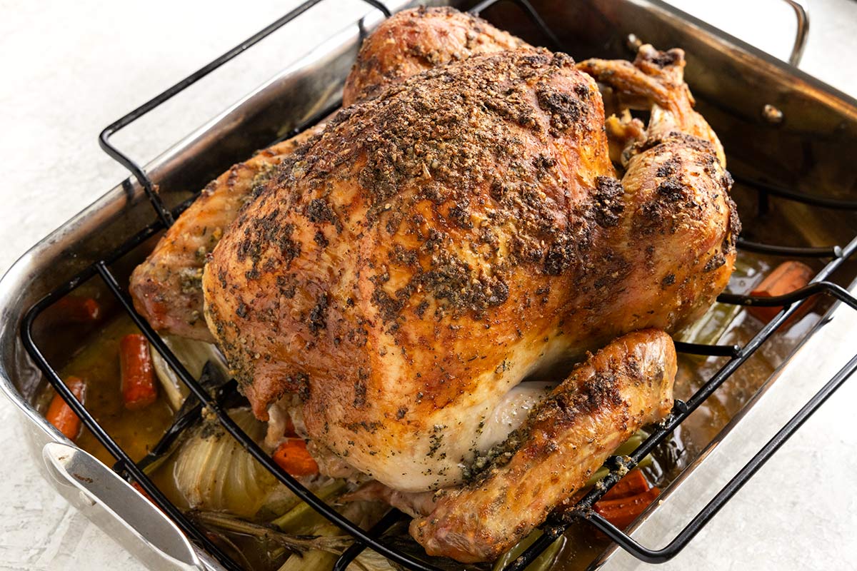 Perfectly cooked herb roasted turkey on a roasting rack.