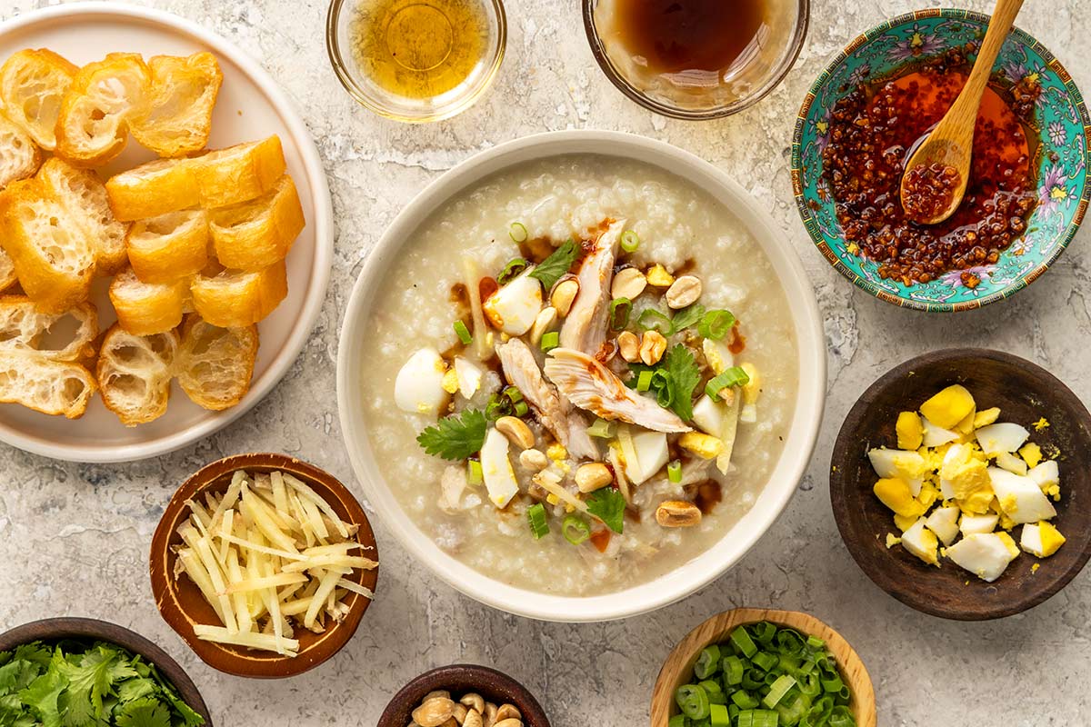Bowl of homemade turkey jook served with different types of garnish.