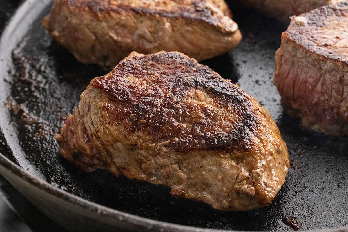 Pan of steak fillets with sear marks.