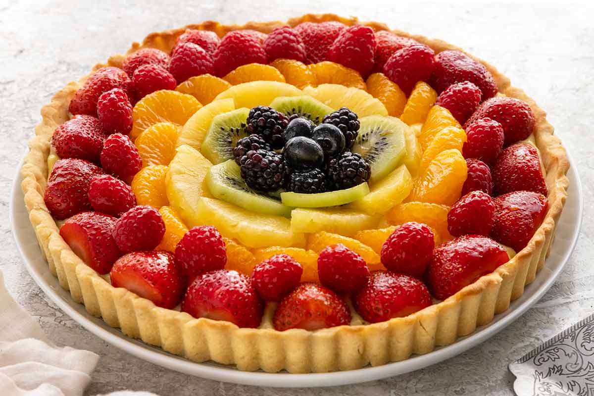 Beautiful fruit tart with orange, strawberries, kiwi, and raspberries.
