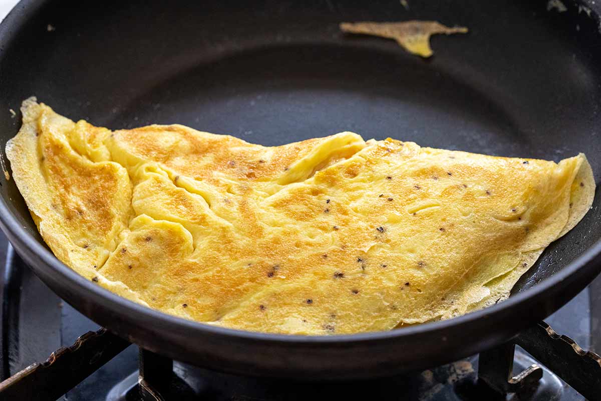 Folded omelet with brown surface color inside a a non stick pan.