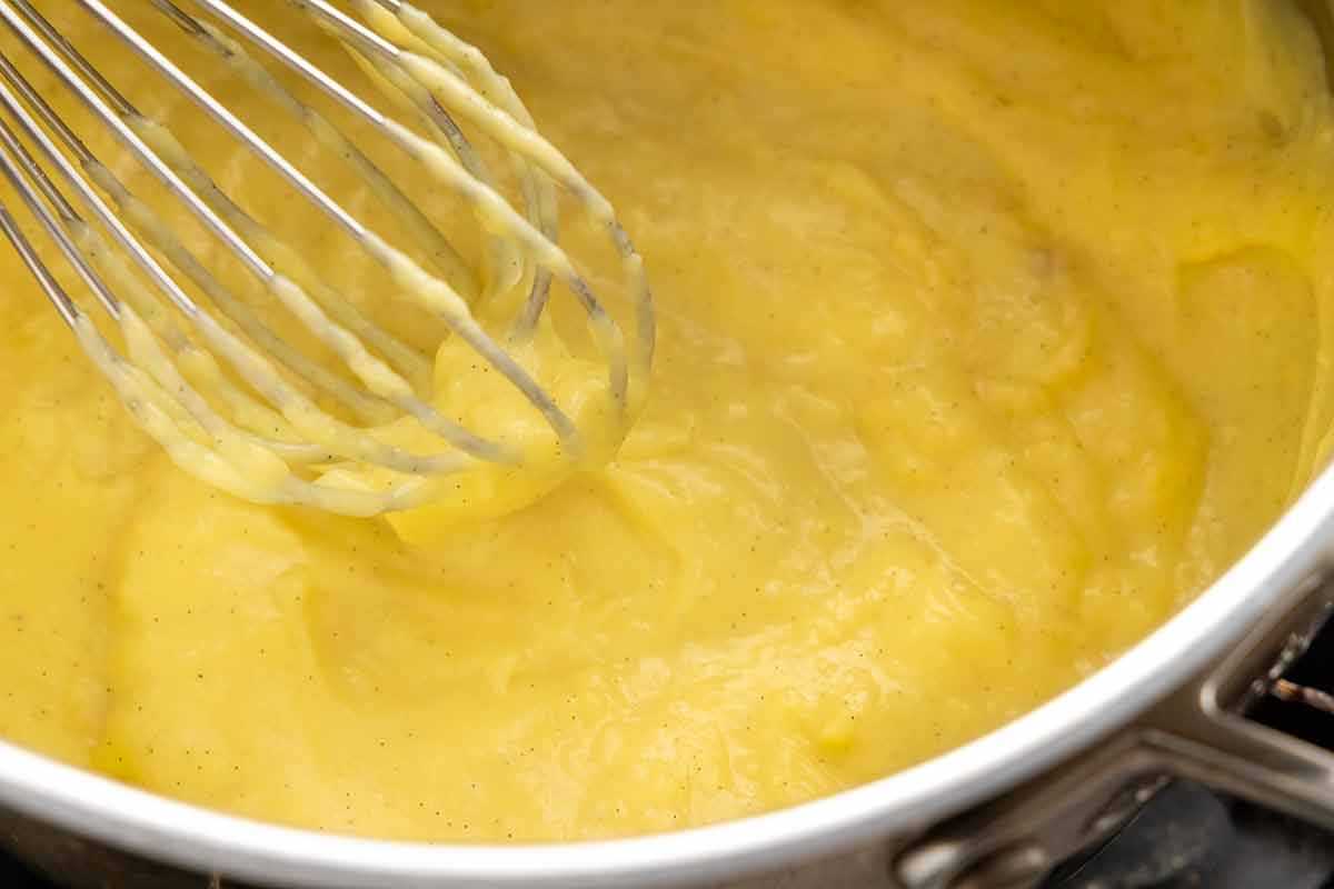 Thickened pastry cream being formed in a saucepan.