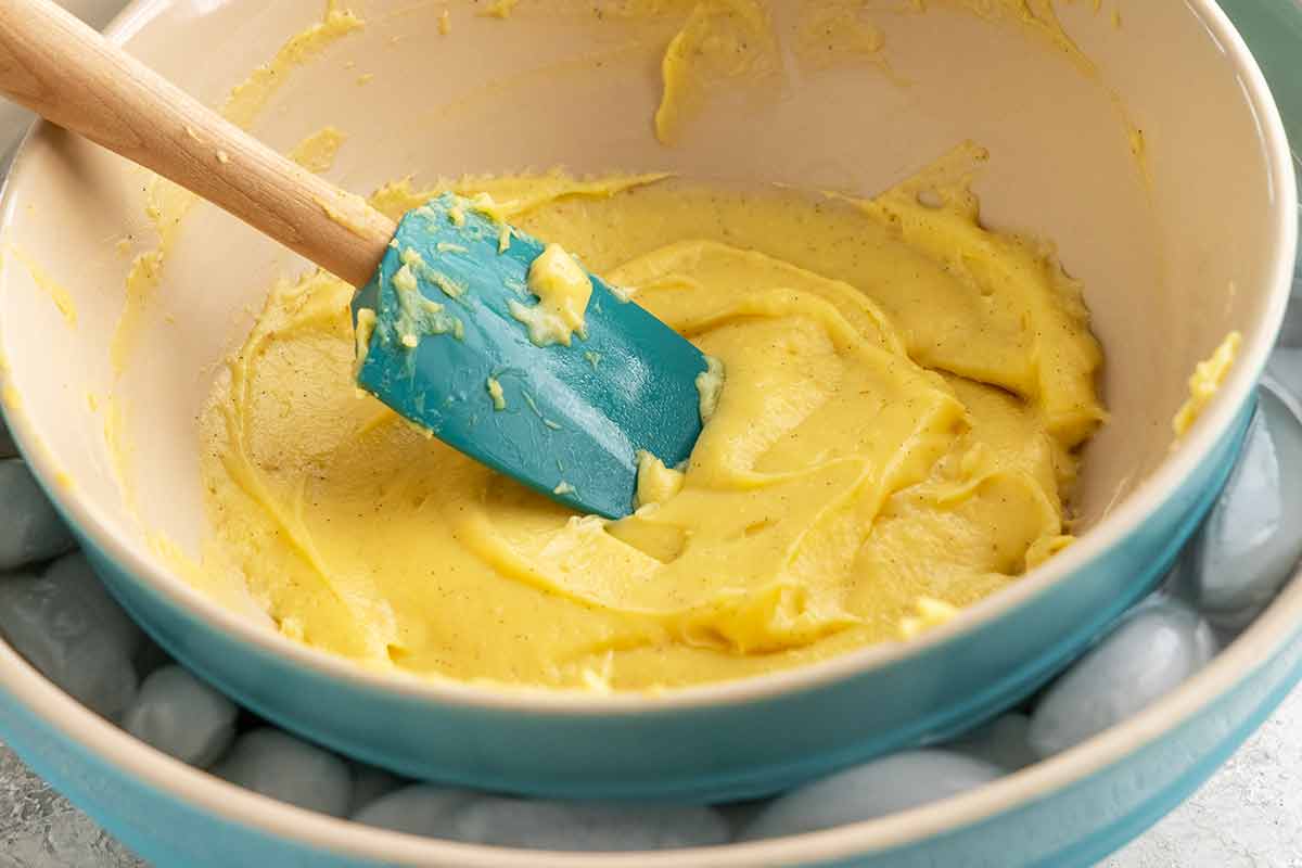 Bowl of pastry cream set over a larger bowl filled with ice cubes.