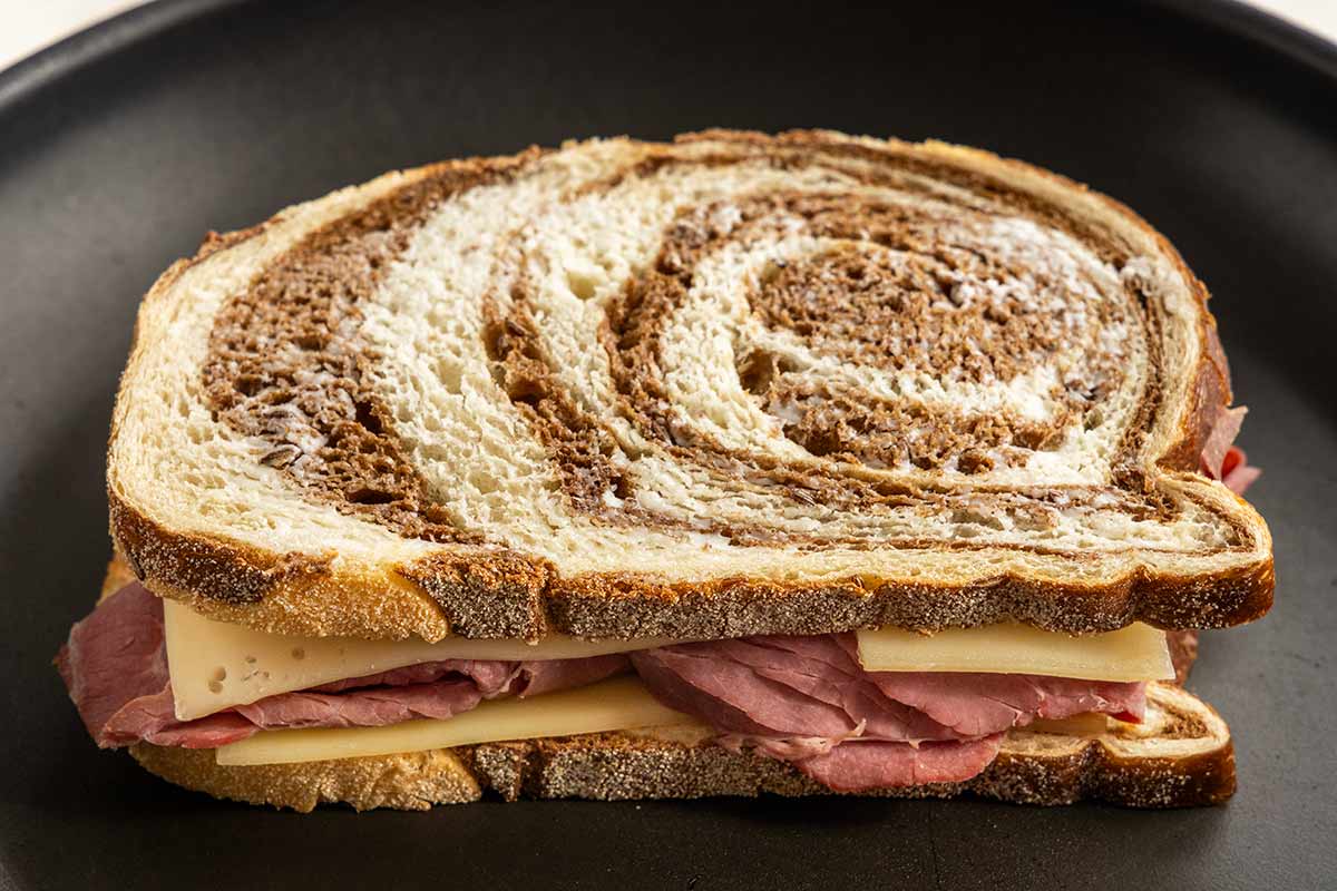 Reuben sandwich being toasted on a frying pan.