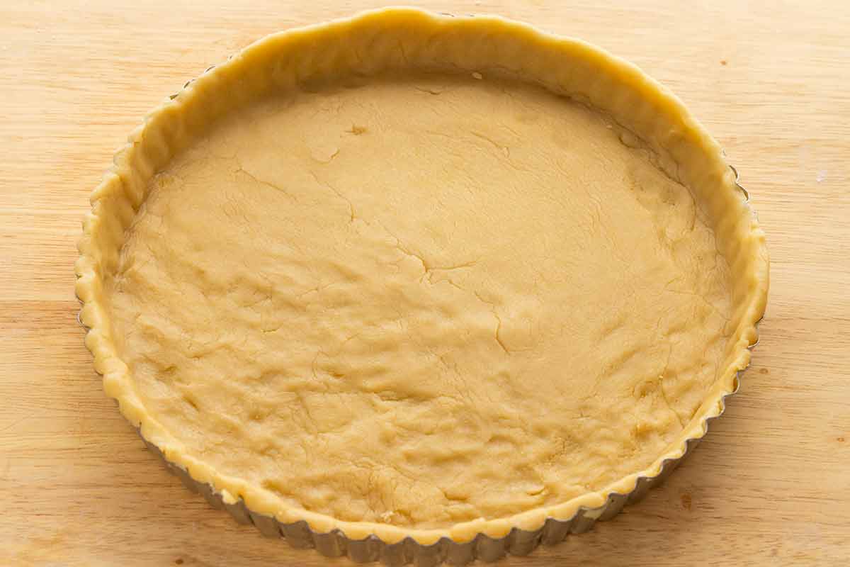 Tart crust dough placed inside a tart crust pie dish.