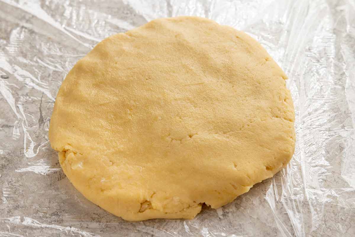 Tart crust dough formed into a disk and wrapped in plastic.