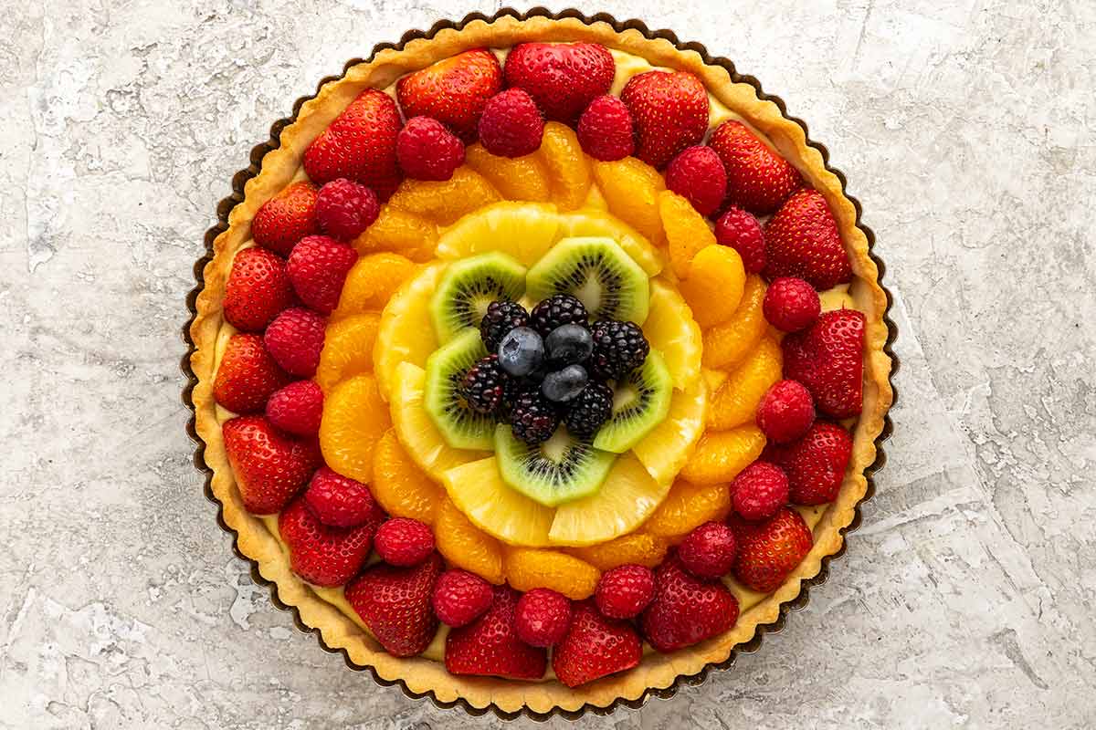 Beautiful fresh fruit tart with oranges, strawberries, kiwi, and raspberries.