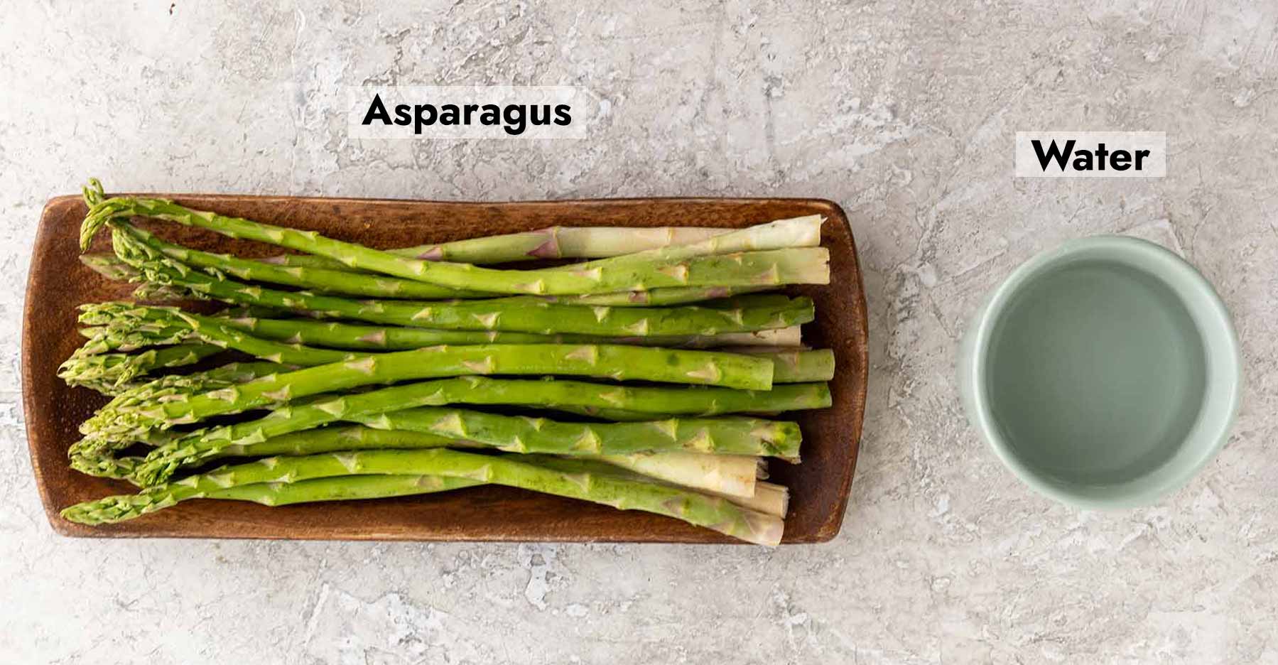 Picture of asparagus next to a bowl of water.