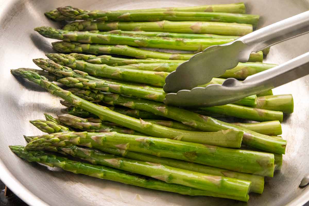 Asparagus stalks in a stainless steel pan.