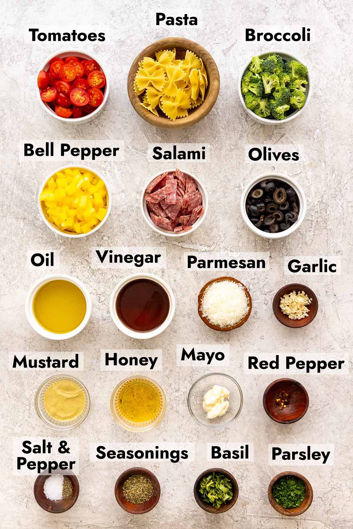 Several bowls with ingredients needed to make a bow tie pasta salad recipe.