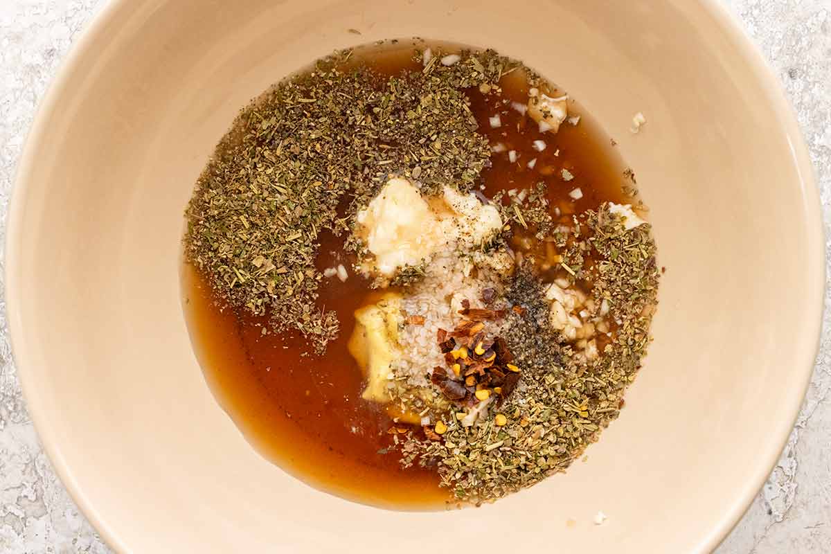 Bowl of mayonnaise, red wine vinegar, and Italian seasonings.