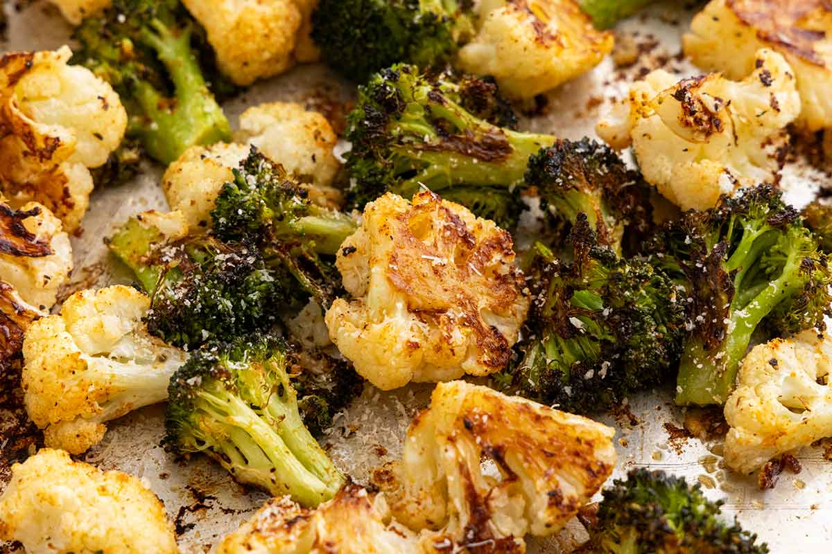 Roasted broccoli and cauliflower florets with golden brown, charred edges and a sprinkle of Parmesan cheese