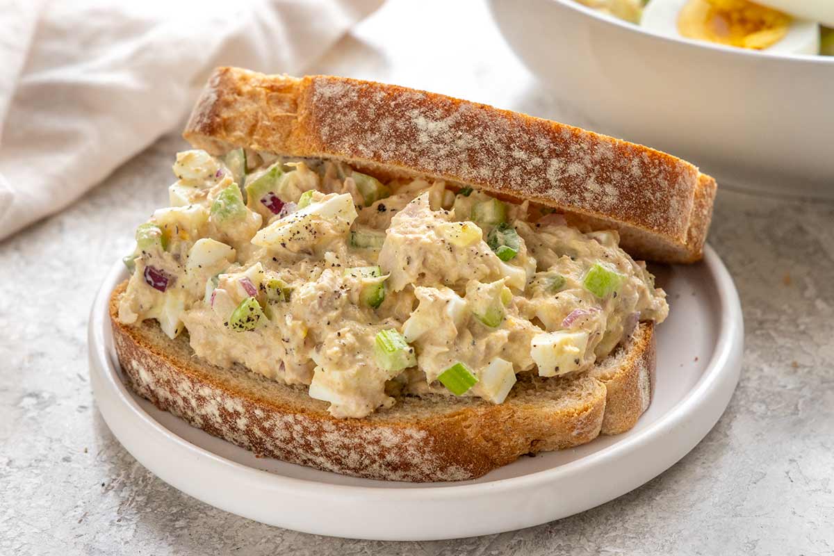 Tuna egg salad sandwich on a small plate.